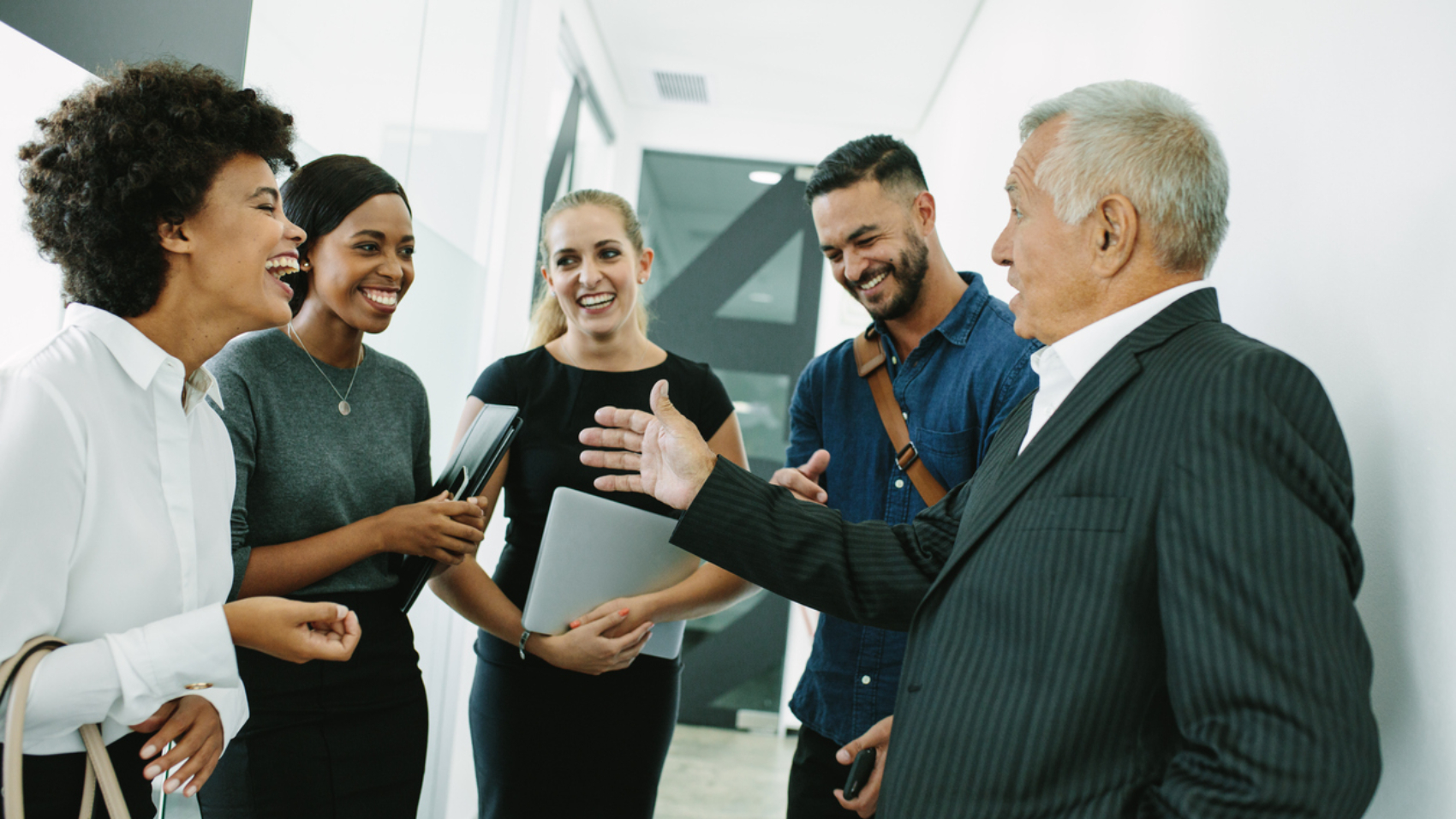 Business people standing together in office having casual discussion. Corporate professional having informal meeting in office corridor.